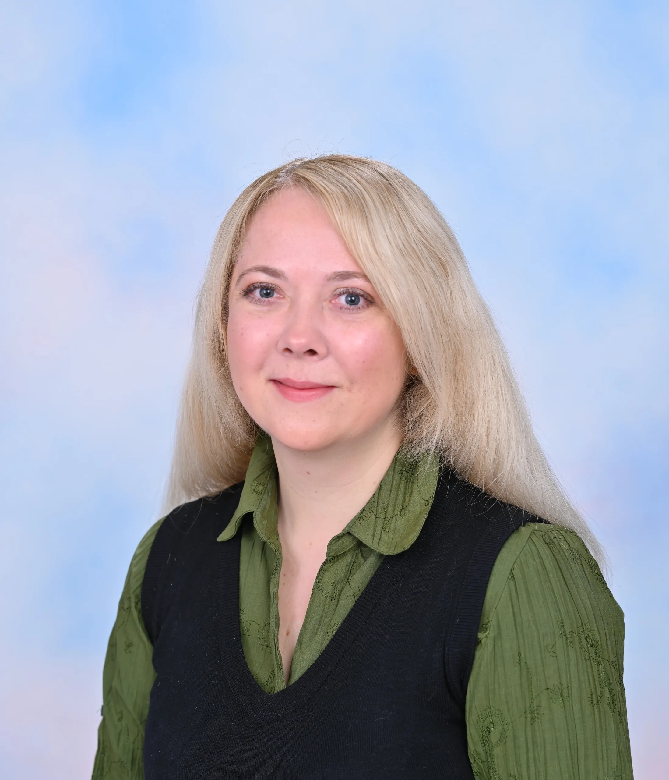 A woman with blonde hair wearing a green shirt.